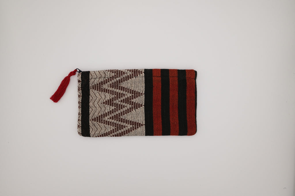 Woven pouch with geometric pattern and red accents on a white background