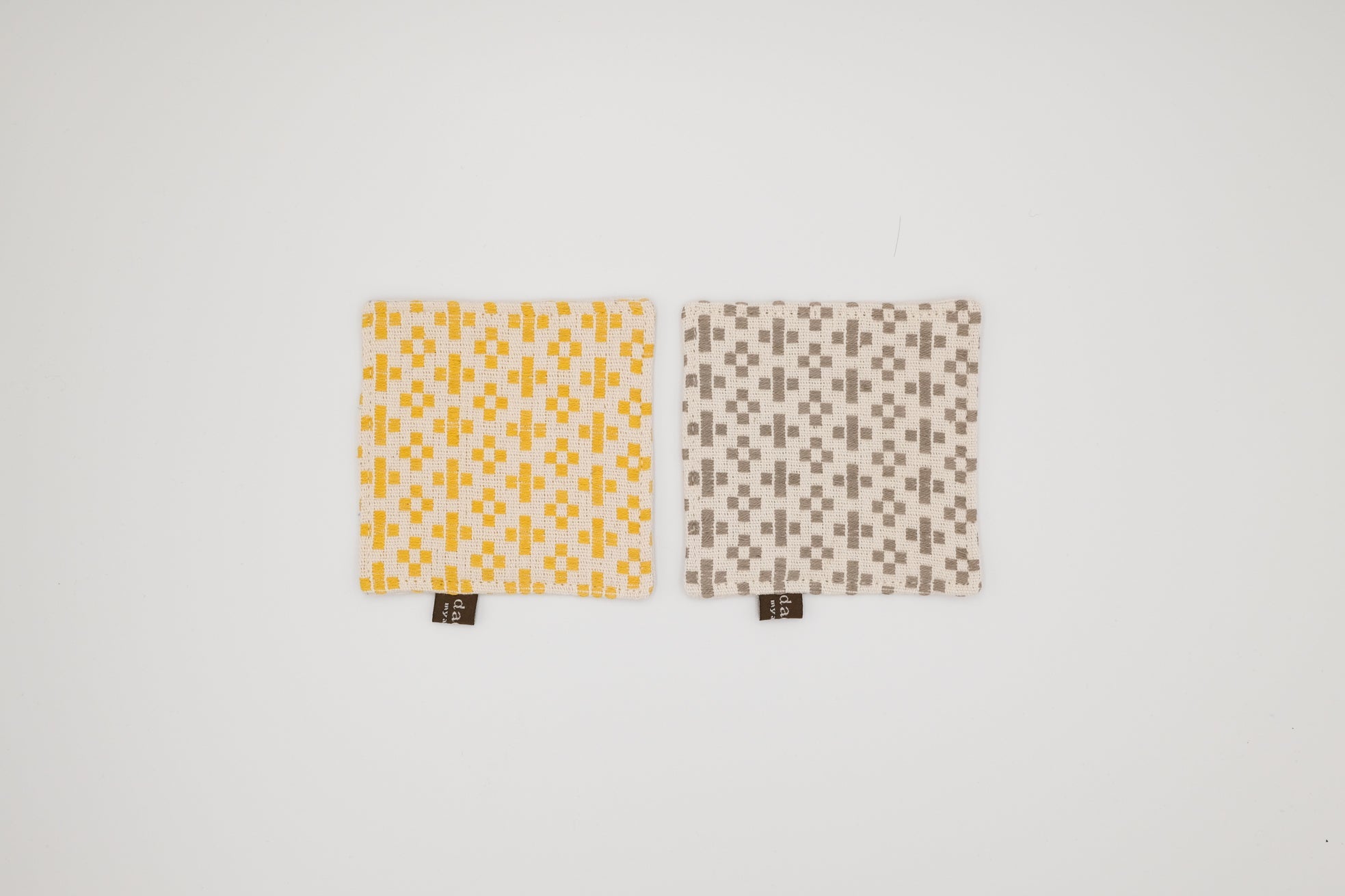 Two fabric coaster with geometric patterns on a white background